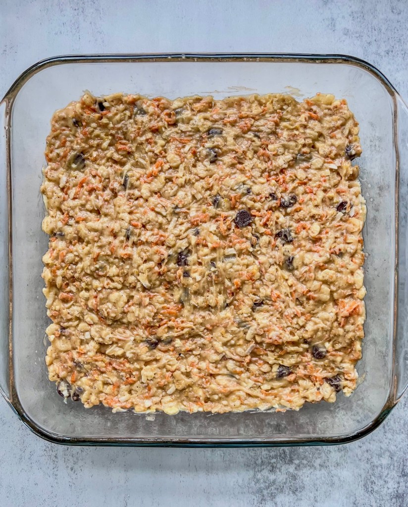 Salted carrot cake crunch bars in a pan just before going into the oven.