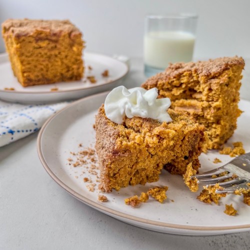 Brown butter pumpkin crumb cake served with whipped cream on top and a glass of milk