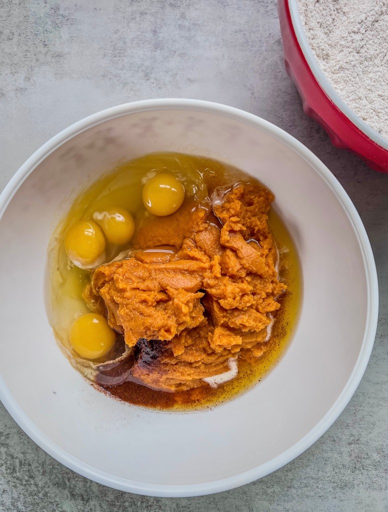 Brown butter, canned pure pumpkin, eggs, vanilla, and espresso powder in a mixing bowl.