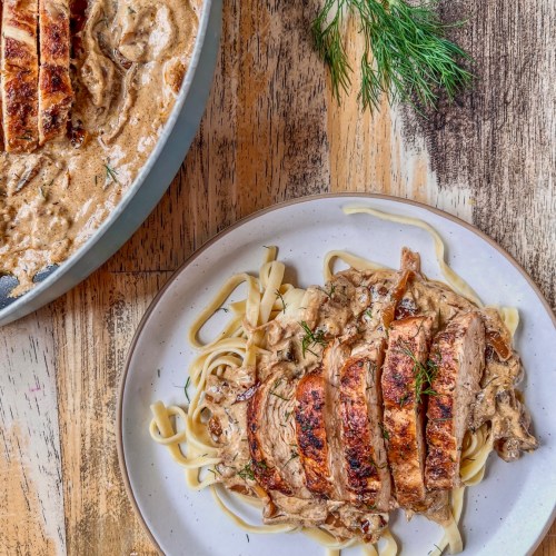 Caramelized onion chicken skillet served on a plate with some fresh dill sprinkled on top.