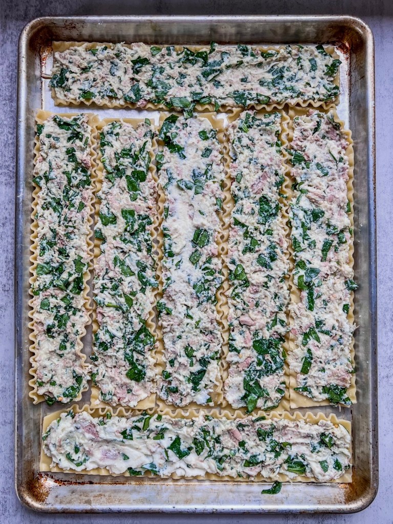 Lasagna noodles that have been spread with a creamy spinach tuna mixture.
