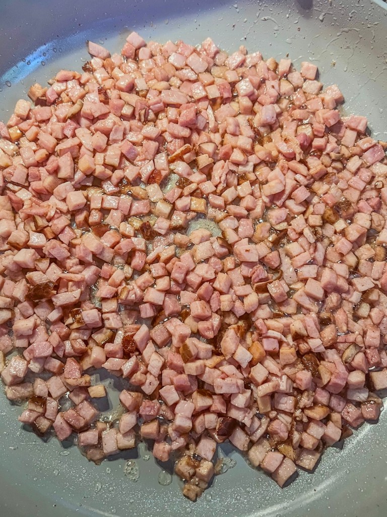 Cubed ham cooking in a skillet in some bacon grease.