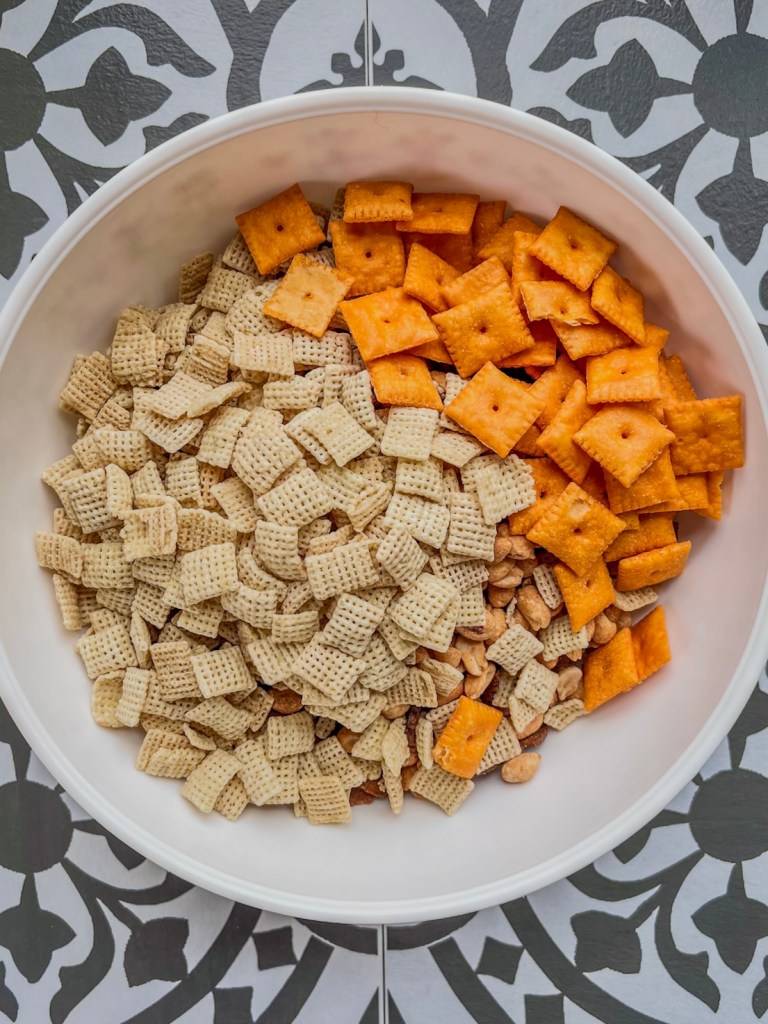 Chex cereal, cheese crackers, peanuts, pretzels, and rye chips in a large mixing bowl.