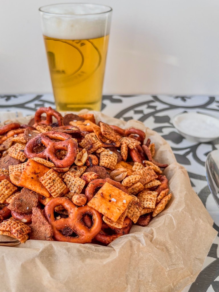 Hot honey dill pickle snack mix served with some dried dill and flaky salt dusted on top.