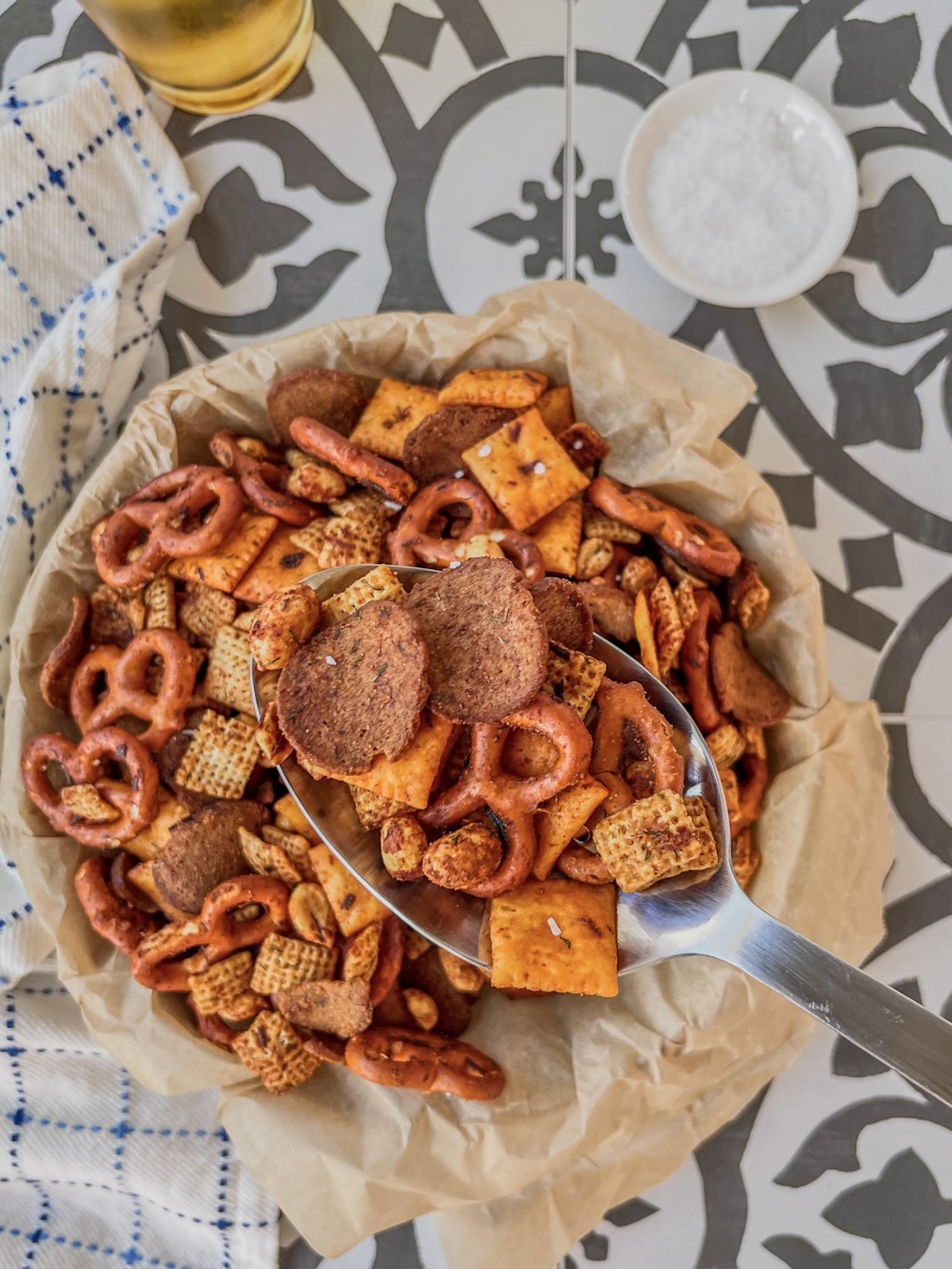 Hot honey dill pickle snack mix in a serving dish with dried dill and flaky salt sprinkled on top.
